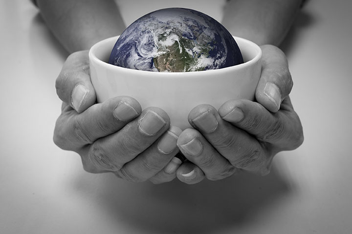 Person holding out bowl with globe inside in need of solar refrigeration